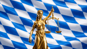 Goldene Justitia mit Waage vor bayerischer Flagge als Symbol für Recht und Religionsfreiheit